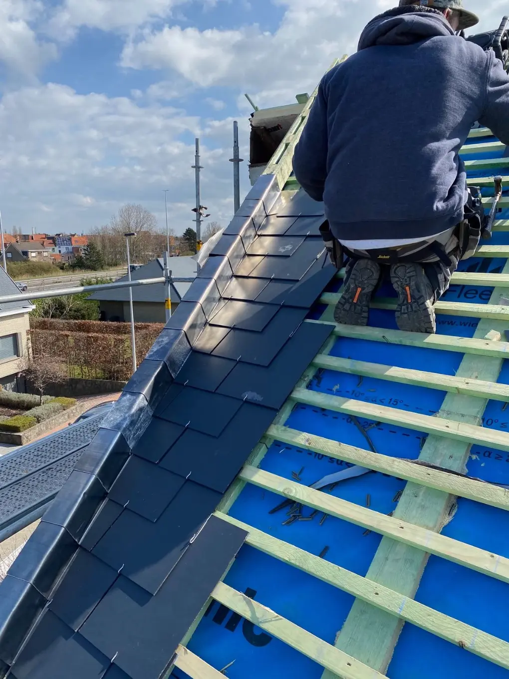 Dakwerker van Dak & Co plaatst leien op een dak